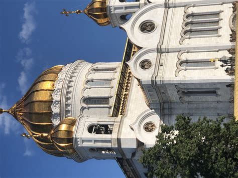 Two Large White Buildings With Gold Domes Against A Blue Sky