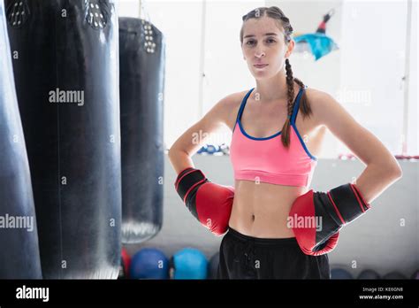 Portrait determined, tough young female boxer wearing boxing gloves ...