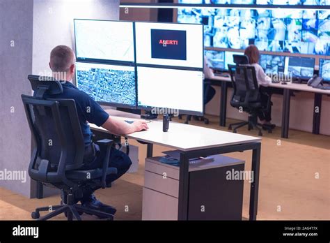 Security Guard Monitoring Modern Cctv Cameras In Surveillance Room