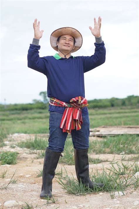 Handsome Asian Man Farmer Stands At Agricultural Land Stock Photo