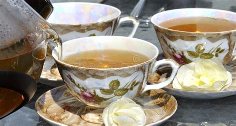 Pouring Tea From Porcelain Tea-kettle Into Cup. Stock Photo - Image of porcelain, drink: 25070446