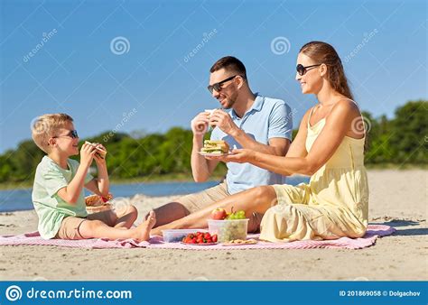 Familia Feliz Que Tiene Picnic En La Playa De Verano Foto De Archivo