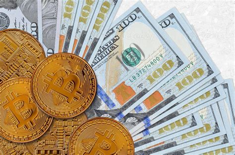 Billetes de 100 dólares estadounidenses y bitcoins dorados concepto de