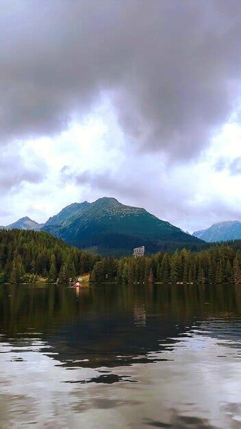 Vista De Un Lago De Montaña Y Un Bote En El Agua Con Picos De Montaña