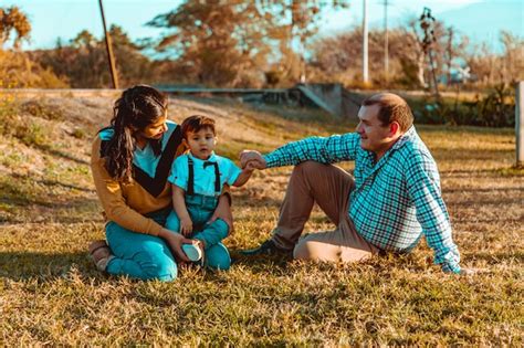 Familia Con Hijo Sentado En La Hierba Foto Premium