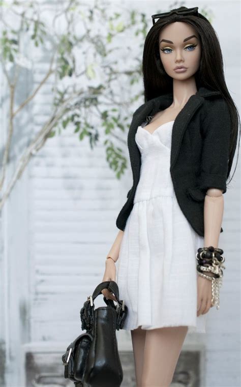 A Doll Dressed In White And Black Holding A Purse