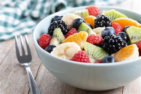 Ensalada De Frutas En Un Cuenco Azul En Una Mesa De Madera Foto Gratis