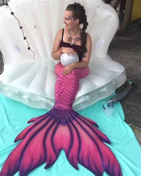 A Woman Sitting On An Inflatable Chair With A Pink Mermaid Tail And