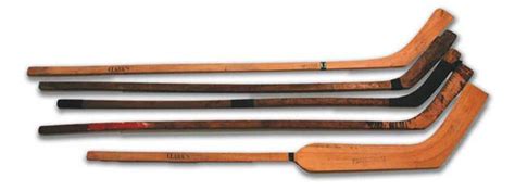 Five Wooden Hockey Sticks Lined Up On Top Of Each Other