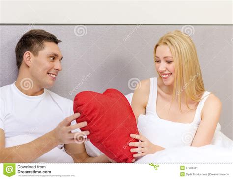 Smiling Couple In Bed With Red Heart Shape Pillow Stock Image Image Of Honeymoon Home 37231431