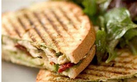 A Close Up Of A Sandwich On A Plate With Lettuce And Tomato Salad