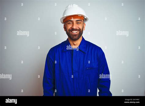 Handsome Indian Worker Man Wearing Uniform And Helmet Over Isolated