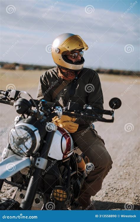 The Man Is Wearing A Helmet Sitting On His Motorcycle In The Desert