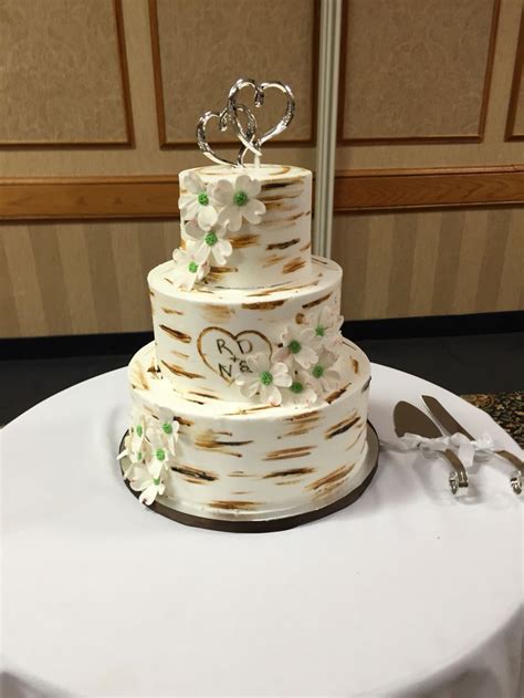 A Wedding Cake Sitting On Top Of A Table Next To A Knife And Utensils