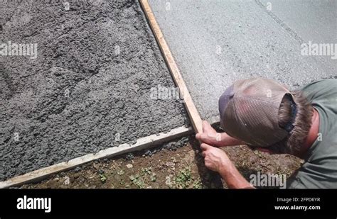 Back Of Mans Head While Screeding Cement Top Down View Stock Video