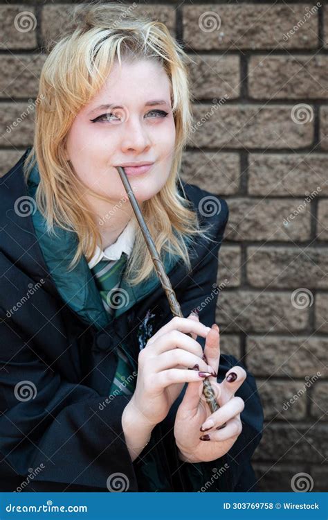 Blonde Caucasian Female Cosplayer Dressed As A Wizard With A Magic Wand