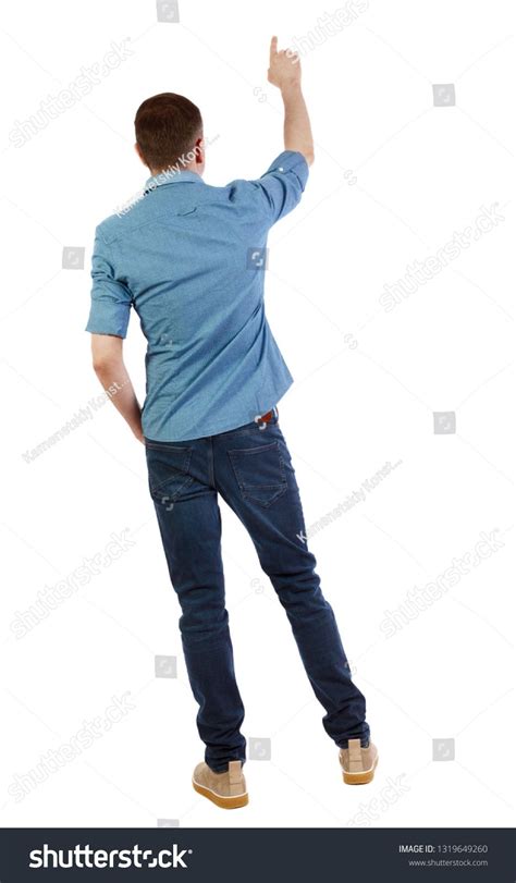 Back View Of A Man In Jeans Points His Hand Upwards Rear View People