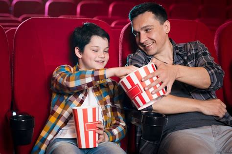 Free Photo Father And Son Watching Movie In Cinema