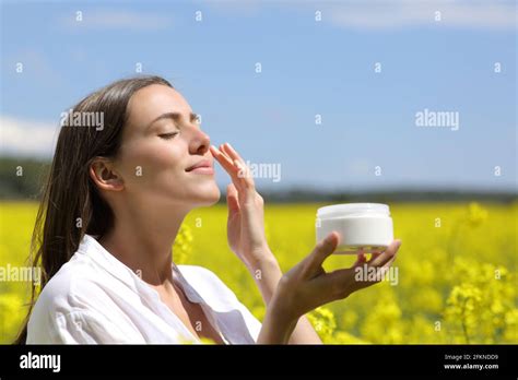 Beauty Woman Holding Jar Applying Moisturizer Cream On Face In A