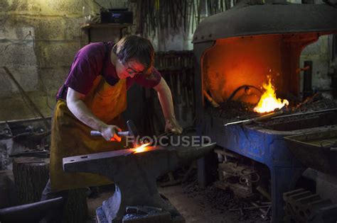 Blacksmith Striking Red Hot Metal Apron Horizontal Stock Photo