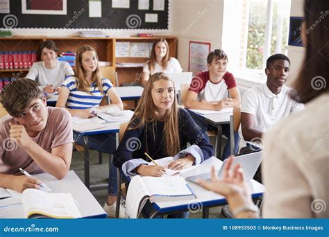 Students Listening To Female Teacher In Classroom Stock Image Image