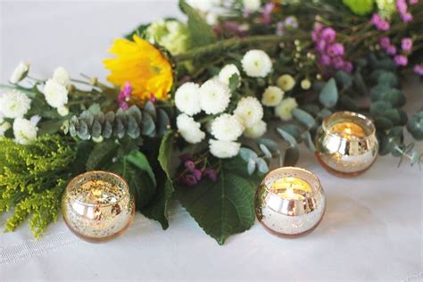 Flowers And Candles On A Table With White Linen Greenery And Yellow