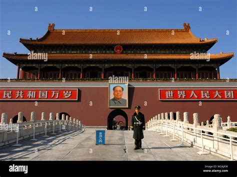 Guard standing in Tiananmen Square in front of the Gate of Heavenly Peace with a portrait of Mao ...