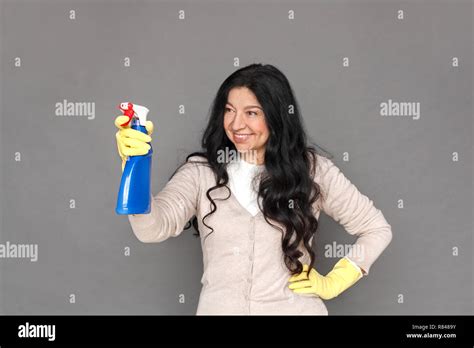Freestyle Mature Lady In Rubber Gloves Standing Isolated On Grey
