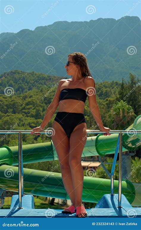 Girl At The Height Of The Water Park Posing In A Swimsuit Stock Image