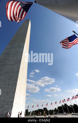 The Washington Monument With Two American Flags Located In Washington