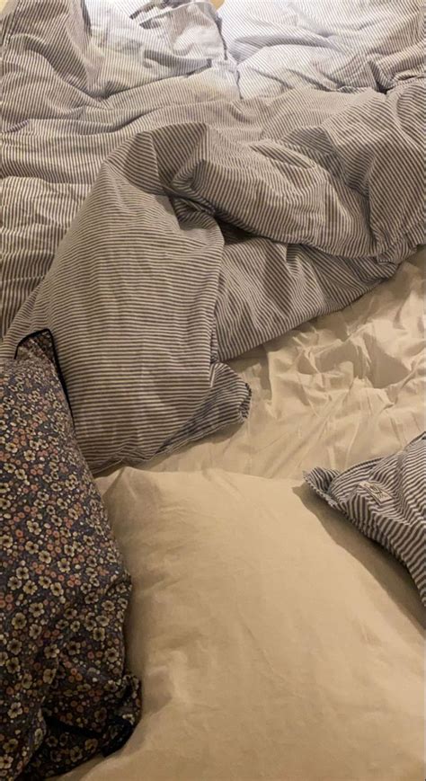 An Unmade Bed With Many Pillows And Blankets