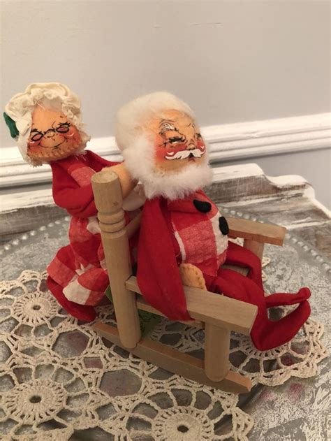 A Santa Clause Doll Sitting On Top Of A Wooden Rocking Chair