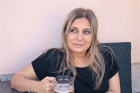 Premium Photo Smiling Mature Woman Drinking Beer