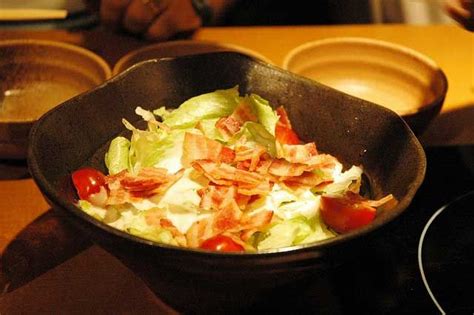 A Bowl Filled With Salad Sitting On Top Of A Stove