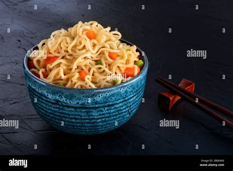 Instant Noodles Bowl With Carrot And Scallions With Chopsticks On A