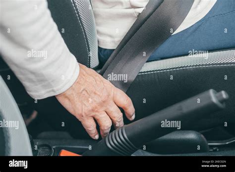 Close Up Of One Mature Woman And Putting On Seat Belt In A Car To Be