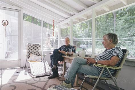 Senior Woman And Adult Son Having Afternoon Tea Together In Covered