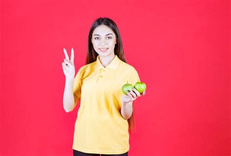 Premium Photo Woman In Yellow Shirt Holding A Green Apple And Feeling