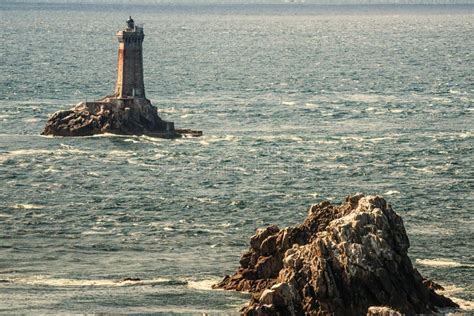 Concrete Lighthouse On A Rock Formation In The Middle Of The Sea During