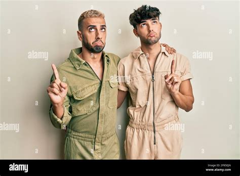 Homosexuel Gay Couple Debout Ensemble Portant Combinaison D Contract E Pointant Vers Le Haut L