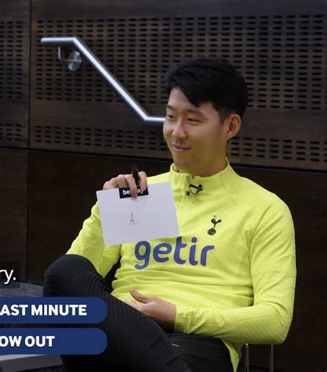 A Man Sitting In A Chair Holding A Piece Of Paper