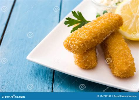 Crispy Fried Fish Fingers With Lemon And Sauce On Blue Wood Stock Image