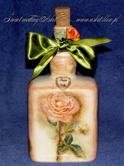 A Small Bottle With A Rose Painted On The Side And A Green Bow Around It