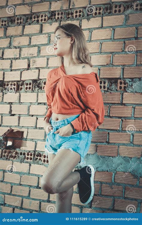 Woman Wearing Brown Long Sleeved Blouse And Blue Denim Short Shorts