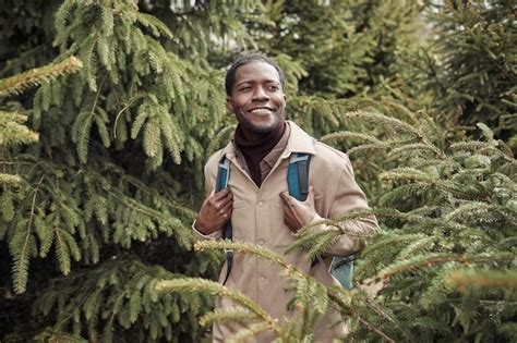 Premium Photo African Man Walking Among Fir Trees