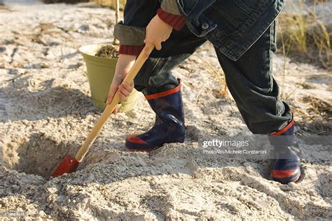 Boy Digging Hole In Sand High-Res Stock Photo - Getty Images