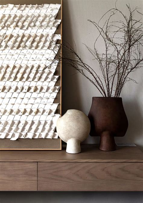 Two Vases With Plants In Them Sitting On A Shelf Next To A Framed