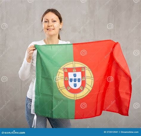 Happy Young Woman Holding Flag Of Portugal Against Unicoloured