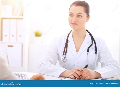 Brunette Female Doctor Talking To Patient At Hospital Office Physician Says About Medical Exams
