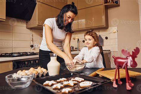 mère avec sa petite fille préparant de la nourriture dans la cuisine et